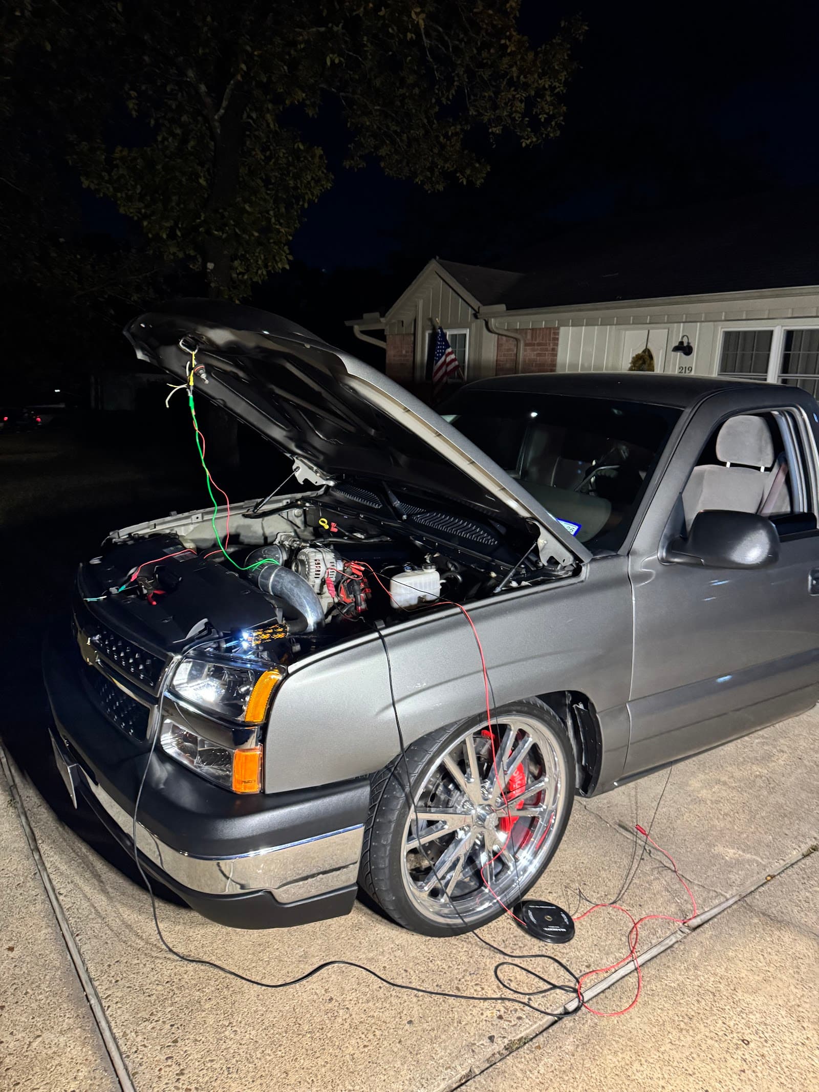 A custom truck getting engine work in a driveway by NXT_L3VL at night