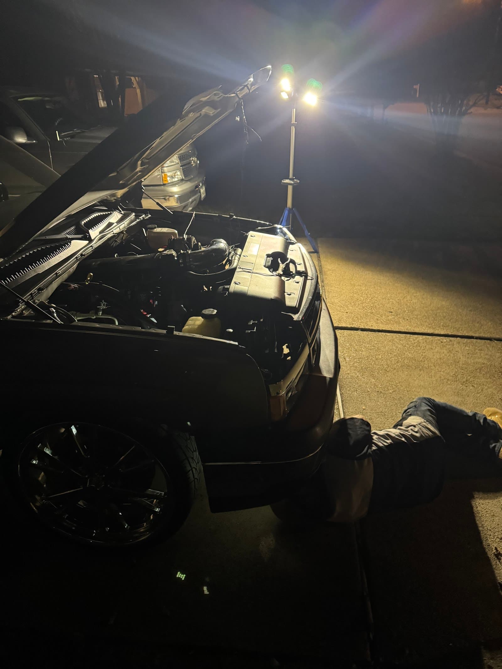 Brian working under the hood at night under work lights